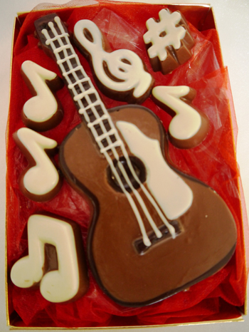 a picture of a milk chocolate guitar decorated with white and dark chocolate