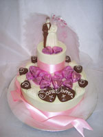milk and white chocolate bride and groom decorated with initialed love hearts on a chocolate tier
