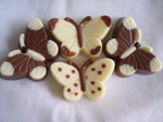 a picture of four small chocolate butterflies, decorated with milk and white chocolate