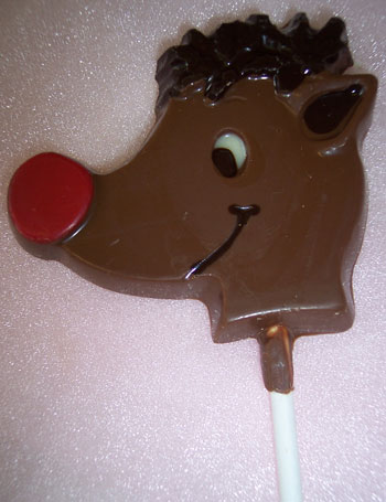 a picture of a small red nose raindeer  on a stick decorated with milk dark and coloured chocolate.